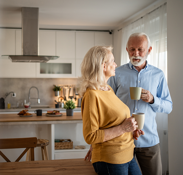 woman and man enjoying coffee in their kitchen at home